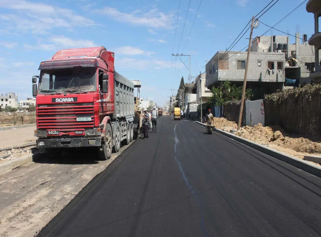 Newly paved road with company trucks